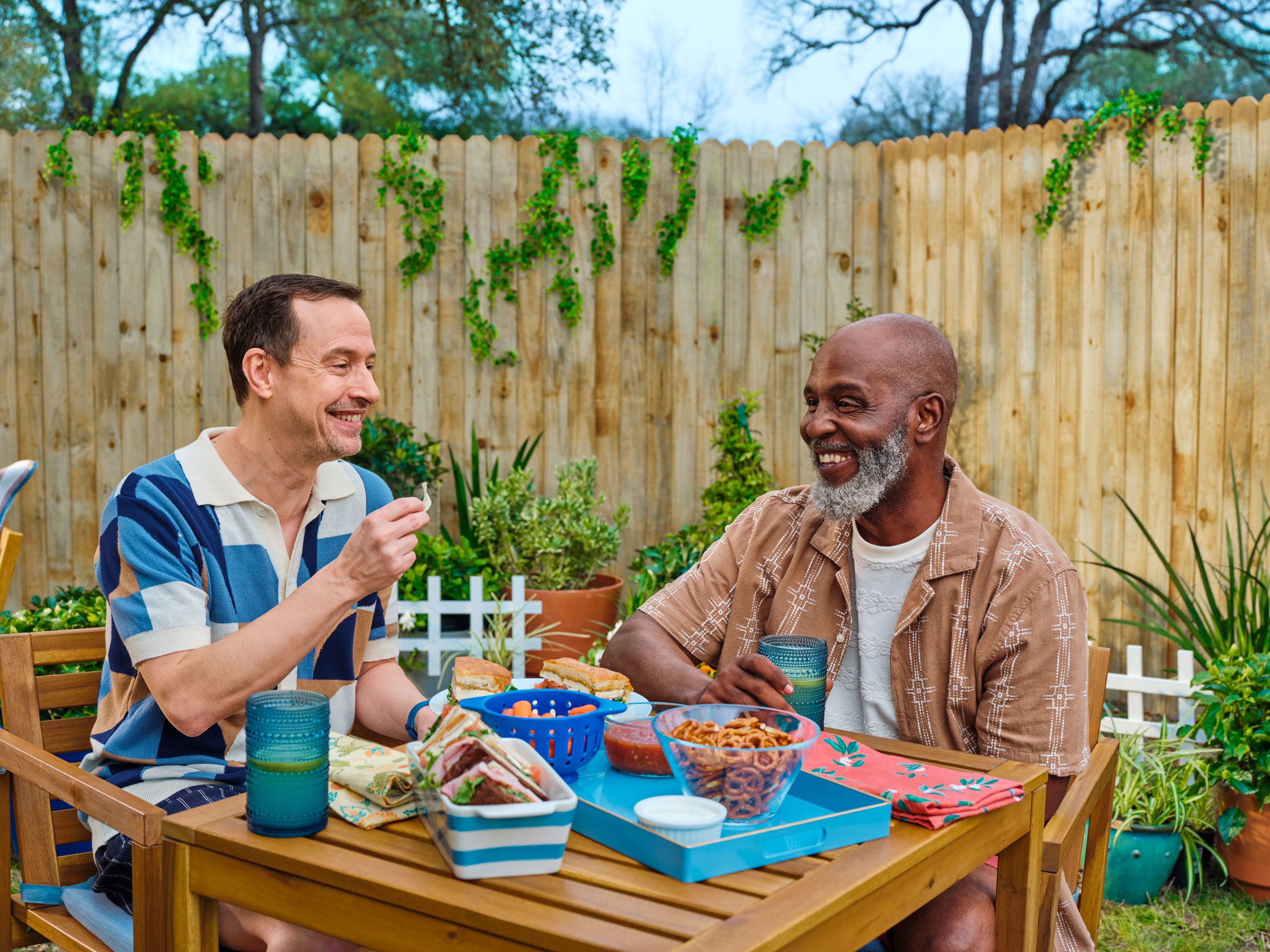 Two patients enjoying a meal in a backyard